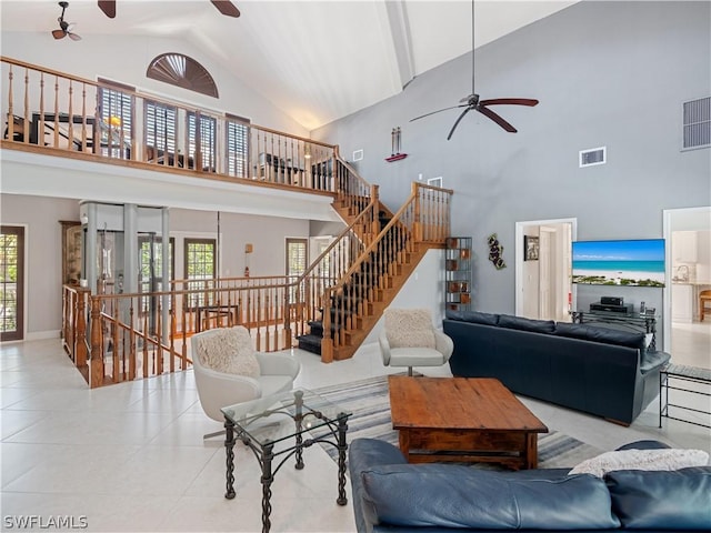 living room with ceiling fan, a towering ceiling, and plenty of natural light