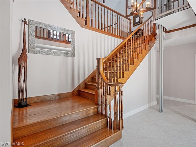 stairs featuring tile patterned flooring and an inviting chandelier