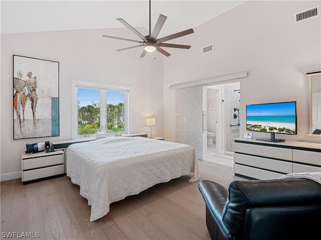 bedroom with high vaulted ceiling, ceiling fan, connected bathroom, and light wood-type flooring