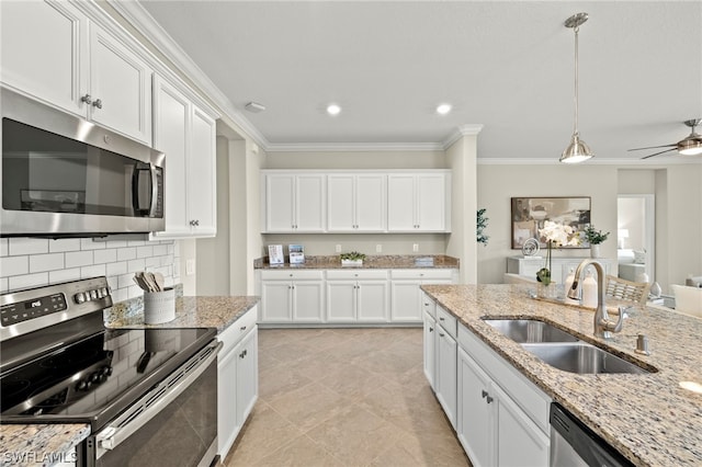 kitchen featuring light stone counters, ornamental molding, stainless steel appliances, sink, and white cabinets