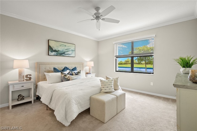 carpeted bedroom featuring ceiling fan and crown molding