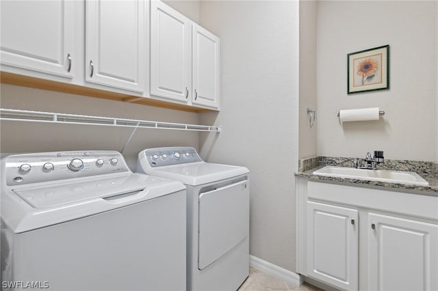 clothes washing area with cabinets, light tile patterned flooring, washer and clothes dryer, and sink