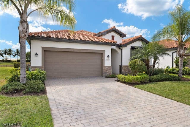 mediterranean / spanish-style house with a garage and a front lawn