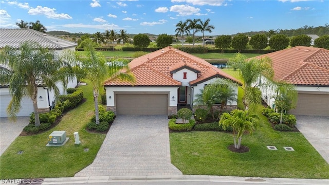 mediterranean / spanish-style home featuring a garage and a front lawn