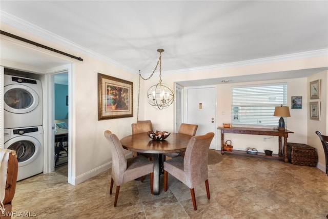 dining area with stacked washer / drying machine, an inviting chandelier, and ornamental molding