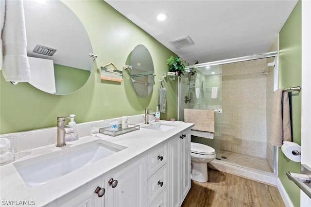 bathroom with vanity, toilet, a shower with shower door, and hardwood / wood-style flooring