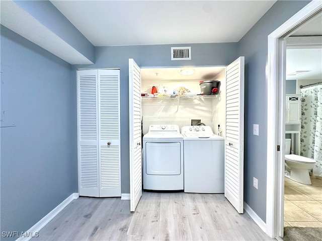 washroom with separate washer and dryer and light hardwood / wood-style floors