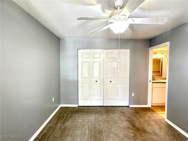 unfurnished bedroom featuring carpet floors, connected bathroom, ceiling fan, and a closet