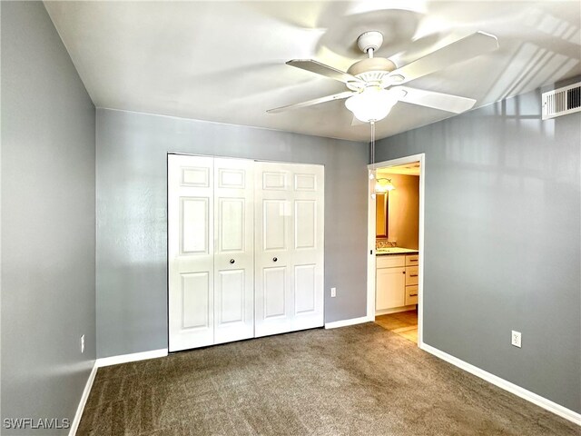 unfurnished bedroom featuring connected bathroom, a closet, ceiling fan, and carpet flooring