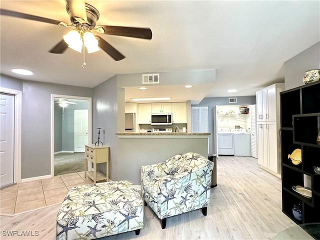 living room with ceiling fan and separate washer and dryer