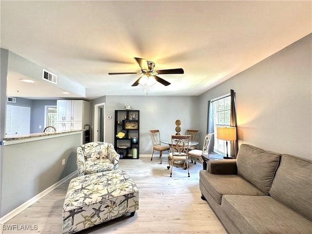 living room featuring light hardwood / wood-style floors and ceiling fan