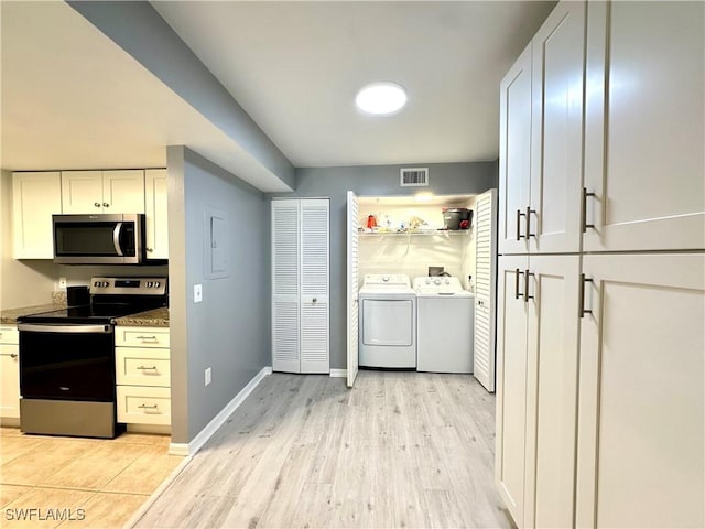 clothes washing area featuring separate washer and dryer and light wood-type flooring