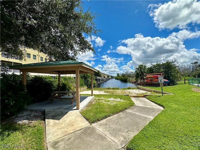 exterior space featuring a gazebo, a water view, a yard, and a patio area