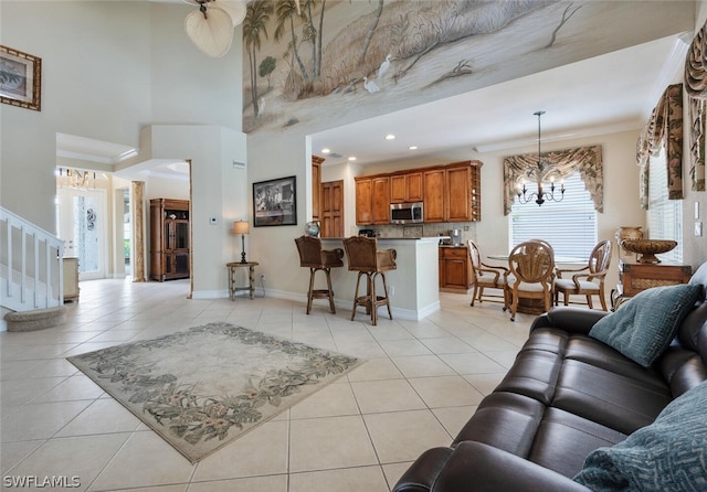 living room with a towering ceiling, plenty of natural light, light tile patterned flooring, and ornamental molding