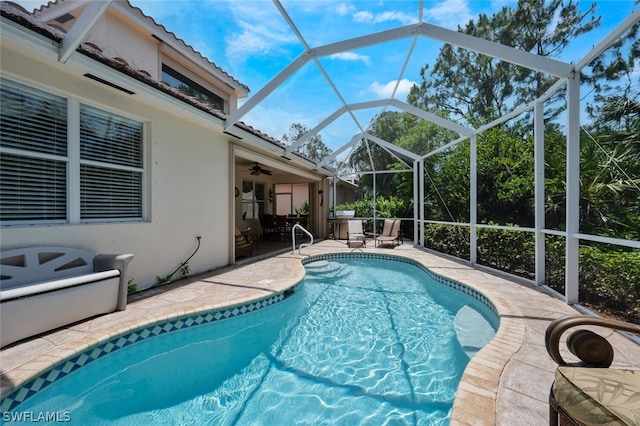 view of swimming pool with a lanai, a patio area, and ceiling fan