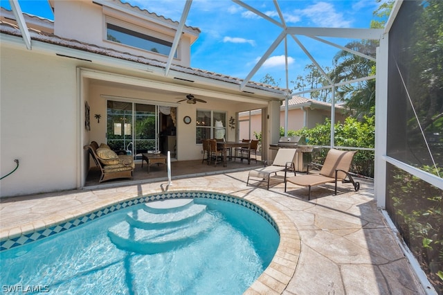 view of swimming pool with a lanai, ceiling fan, and a patio area