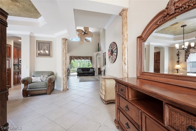 hallway with an inviting chandelier, a raised ceiling, ornamental molding, and light tile patterned flooring