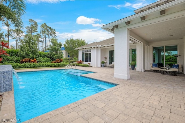 view of swimming pool featuring pool water feature and a patio