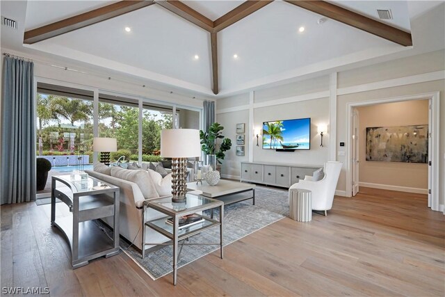 living room with high vaulted ceiling, beamed ceiling, and light hardwood / wood-style floors