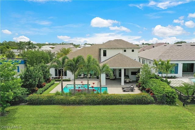 rear view of house featuring a lawn, a fenced in pool, and a patio