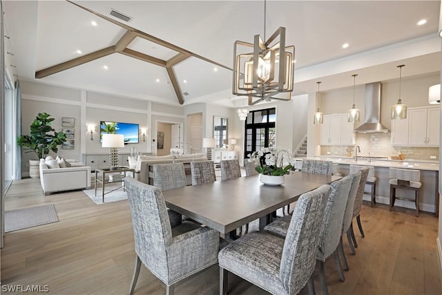 dining room featuring high vaulted ceiling, light wood-type flooring, beamed ceiling, and a chandelier