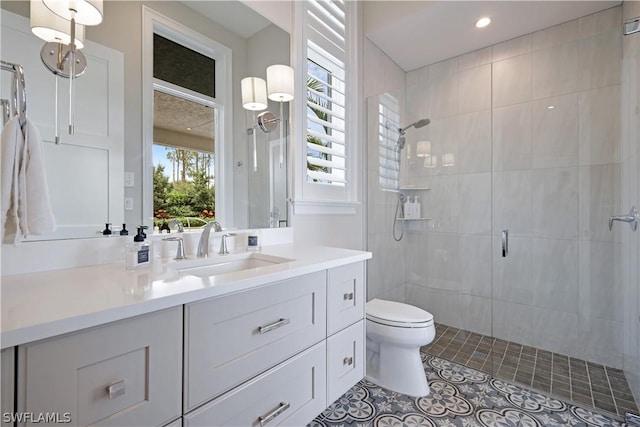 bathroom with toilet, vanity, tile patterned floors, and walk in shower