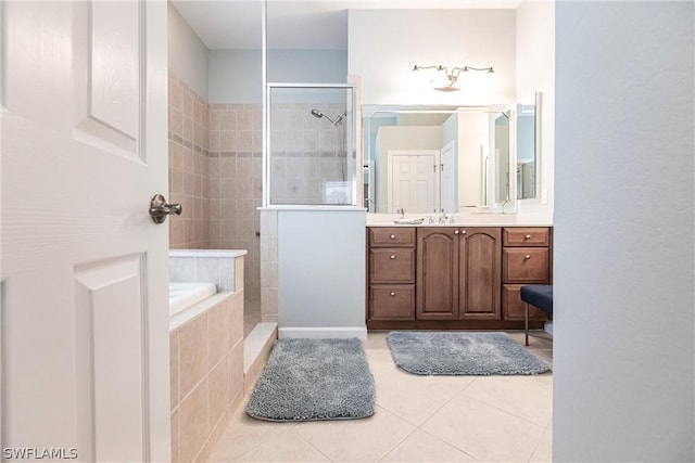 bathroom featuring tile patterned flooring, tiled shower, and vanity