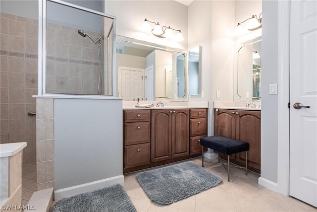 bathroom featuring a tile shower, tile patterned floors, and vanity