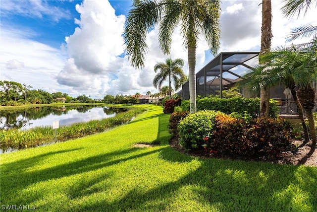 view of yard featuring a water view and glass enclosure