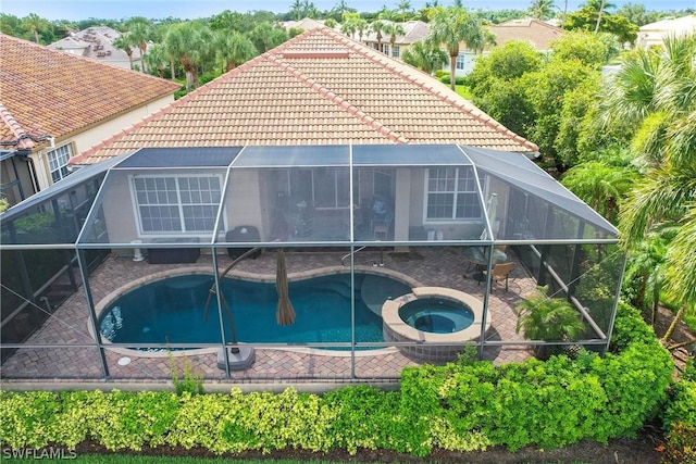 back of house with a pool with hot tub and a lanai