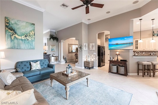 living room featuring ceiling fan, light tile patterned flooring, and crown molding