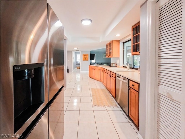 kitchen with a wealth of natural light, sink, light tile patterned floors, and appliances with stainless steel finishes