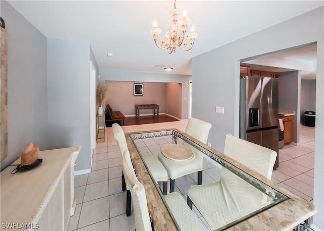 dining room with light tile patterned floors and an inviting chandelier