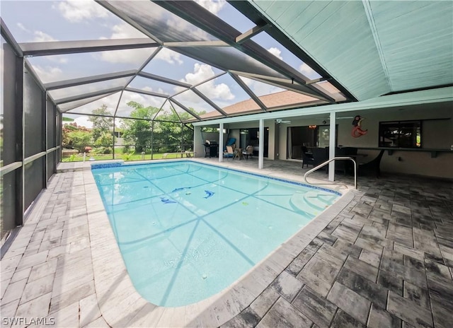 view of pool featuring a patio, glass enclosure, and ceiling fan