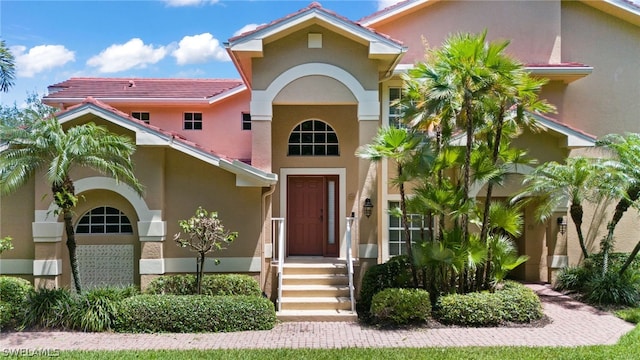 view of front facade featuring a tiled roof and stucco siding