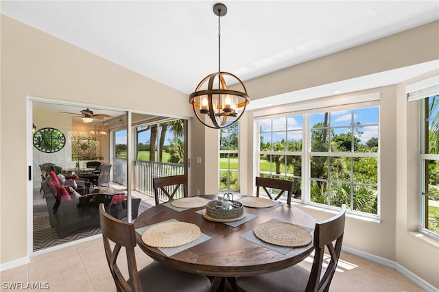 dining area featuring ceiling fan with notable chandelier, light tile patterned floors, and lofted ceiling