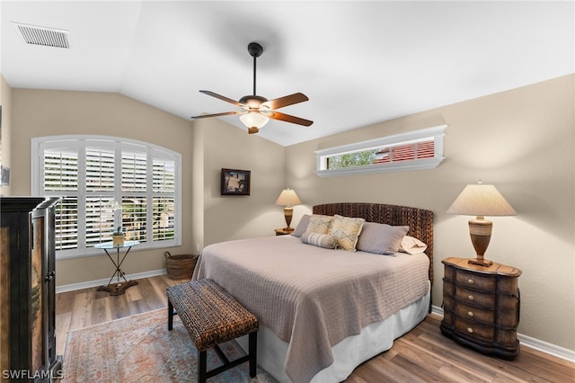 bedroom featuring visible vents, multiple windows, lofted ceiling, and wood finished floors