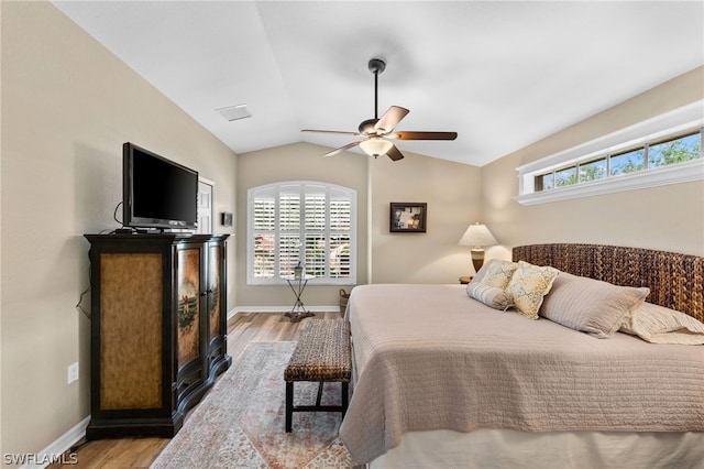 bedroom with light hardwood / wood-style floors, vaulted ceiling, and ceiling fan