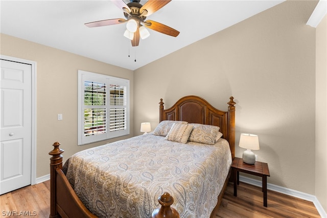 bedroom with light wood-style flooring, a ceiling fan, and baseboards