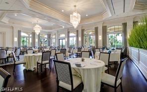 dining area with coffered ceiling, ornamental molding, and a chandelier