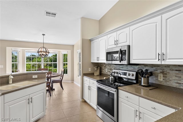 20331 Calice Ct Unit 1704, Estero, FL 33928 - kitchen with stainless steel appliances, a sink, tasteful backsplash, a chandelier, and decorative light fixtures