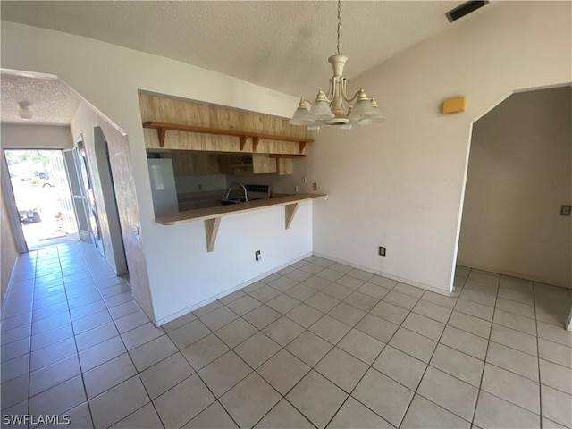 kitchen featuring light tile patterned floors, a breakfast bar area, hanging light fixtures, a notable chandelier, and kitchen peninsula