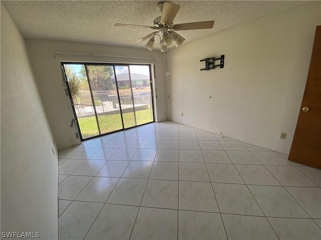 unfurnished room with ceiling fan, light tile patterned floors, and a textured ceiling