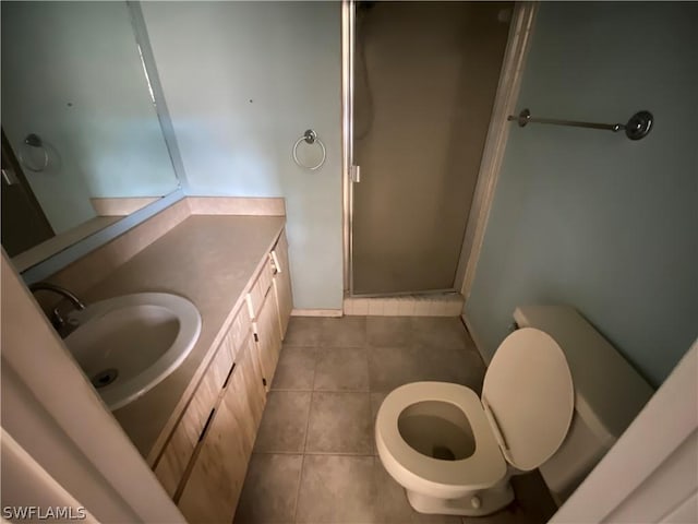 bathroom featuring tile patterned floors, toilet, an enclosed shower, and vanity