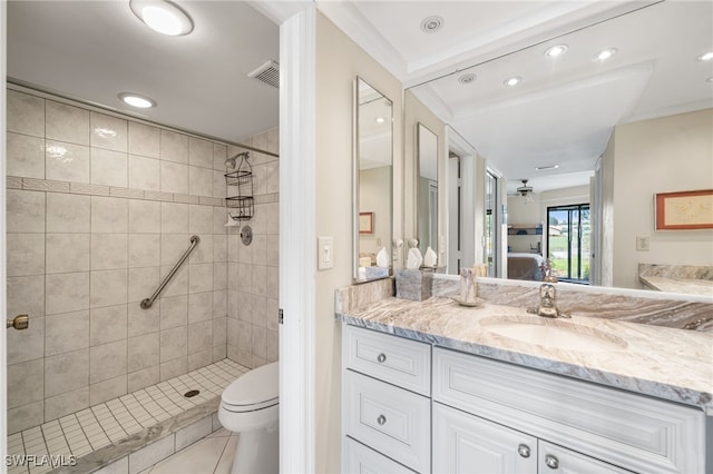 bathroom featuring a tile shower, ceiling fan, tile patterned floors, toilet, and vanity