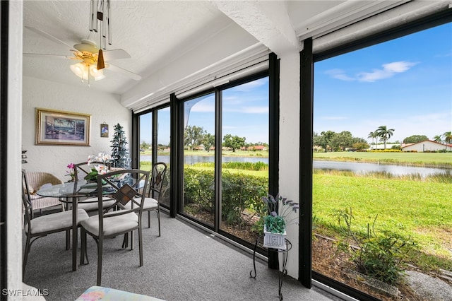 sunroom / solarium with a water view and ceiling fan