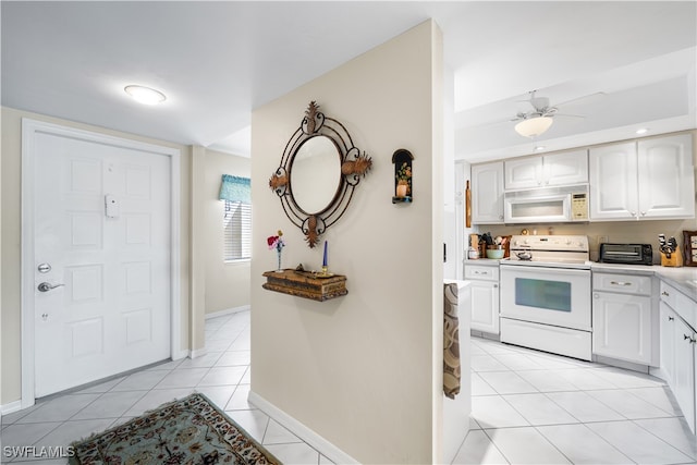 kitchen with ceiling fan, white cabinetry, light tile patterned flooring, and white appliances