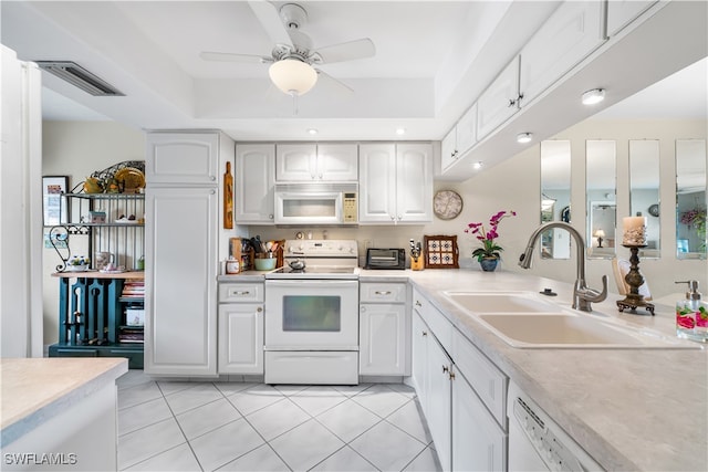 kitchen with white cabinetry, sink, light tile patterned floors, and white appliances