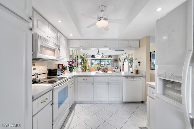 kitchen featuring white appliances, white cabinets, a raised ceiling, sink, and light tile patterned flooring