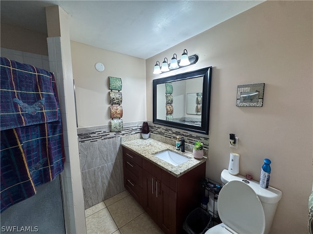 bathroom featuring backsplash, toilet, vanity, tile walls, and tile patterned floors